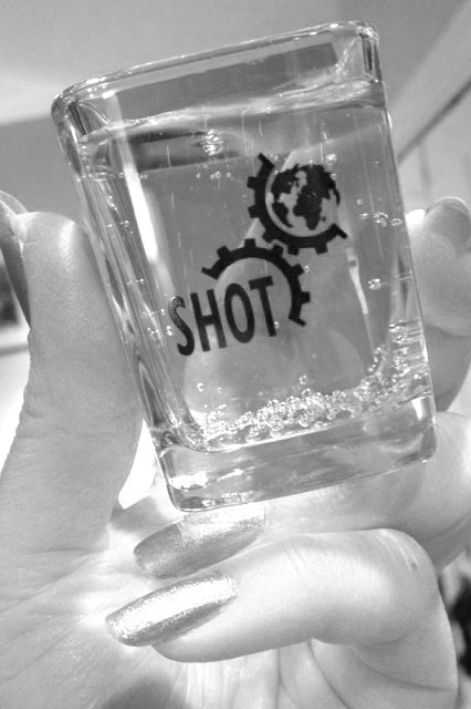 SHOT conference swag: the famous SHOT glass, with the old SHOT logo.  Photo by Marie Hicks (@histoftech)